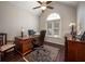 A home office boasts dark wood floors, a ceiling fan, and a large arched window for natural light at 1394 Meadow Springs Dr, Lilburn, GA 30047
