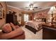 A luxurious primary bedroom features a plush bed, seating area, and elegant decor at 1394 Meadow Springs Dr, Lilburn, GA 30047