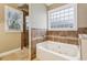 A soaking tub is featured in this bathroom, enhanced by decorative tiles and window at 2187 Rando Ln, Atlanta, GA 30318