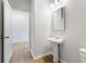 Clean half bath featuring a pedestal sink, mirror, and modern fixtures at 7158 Brushwood Bend (110), Lithonia, GA 30058