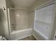 Bathroom featuring a bathtub and shower combination, and a window providing natural light at 1606 Little Creek Dr, Lawrenceville, GA 30045