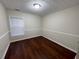 Bedroom with neutral paint, chair railing, hardwood floors, and a window providing natural light at 1606 Little Creek Dr, Lawrenceville, GA 30045