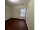 Bedroom features neutral paint, hardwood floors, and a window providing natural light at 1606 Little Creek Dr, Lawrenceville, GA 30045