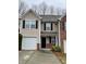 Traditional two-story townhouse with neutral siding, black shutters, and a one-car garage at 1606 Little Creek Dr, Lawrenceville, GA 30045