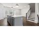 Kitchen island with white countertop and stainless steel sink alongside view of stairs with wood railing at 1729 Lansmere Sw St, Marietta, GA 30008