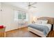 Bright bedroom with hardwood floors, a ceiling fan, and a large bed with white and blue linens at 2528 Fernleaf Nw Ct, Atlanta, GA 30318