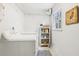 Bright laundry room with white washer and dryer, storage shelves, and a window at 2528 Fernleaf Nw Ct, Atlanta, GA 30318