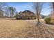 Spacious backyard featuring a large lawn, mature trees, and a two-story home with a deck and sunroom at 30 Magnolia Dr, Oxford, GA 30054