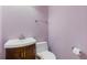 This half bath features a wood cabinet vanity, and modern toilet, all under gentle violet walls at 30 Magnolia Dr, Oxford, GA 30054