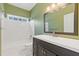 Well-lit bathroom featuring green walls, black vanity and white tiled shower/tub at 30 Magnolia Dr, Oxford, GA 30054