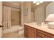 Well-lit bathroom featuring a shower-tub combo, vanity with stone countertop, and decorative mirror at 505 Rocking Porch Way, Woodstock, GA 30189