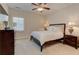 Comfortable bedroom with a ceiling fan, neutral paint, and a wooden bed frame, perfect for relaxation at 505 Rocking Porch Way, Woodstock, GA 30189