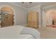 Bright bedroom with ensuite bathroom and arched doorways, decorative armoire and neutral decor at 505 Rocking Porch Way Way, Woodstock, GA 30189