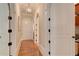 Hallway with arched doorways, hardwood floors, white trim, and elegant lighting fixtures at 505 Rocking Porch Way, Woodstock, GA 30189