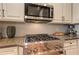 Close up of a stainless steel range and microwave with granite counters, cabinet space and kitchen aid mixer at 505 Rocking Porch Way Way, Woodstock, GA 30189