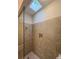 Tile shower stall with shower head, a built in niche and glass partition, under a skylight at 505 Rocking Porch Way Way, Woodstock, GA 30189