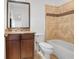 This bathroom features a dark vanity and granite countertops, alongside a white bath with tiled surround at 538 Sarabrook Ne Pl, Atlanta, GA 30342