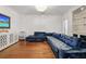 A stylish living room with hardwood floors, a contemporary chandelier, and a large blue velvet sectional sofa at 538 Sarabrook Ne Pl, Atlanta, GA 30342