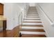 Modern staircase with wood treads, white risers, and a sleek glass railing at 538 Sarabrook Ne Pl, Atlanta, GA 30342