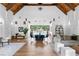 Bright lounge area featuring a high ceiling, exposed beams, and stylish furnishings with access to an outdoor pool at 538 Sarabrook Ne Pl, Sandy Springs, GA 30342