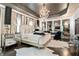 Luxury main bedroom featuring a chandelier, mirrors, and upholstered bed at 538 Sarabrook Ne Pl, Sandy Springs, GA 30342