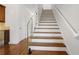 Bright stairway with wood treads, white risers, glass railing, and hardwood floors at 538 Sarabrook Ne Pl, Sandy Springs, GA 30342