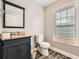 Bathroom featuring modern vanity, granite countertop, toilet, and window at 775 Welch Sw St, Atlanta, GA 30310