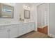 Bright bathroom with white cabinetry, dual sinks, and an open doorway to a closet at 1078 Amarose Ln, Marietta, GA 30066