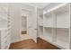 Spacious walk-in closet featuring custom shelving and storage options, complemented by elegant hardwood flooring at 1078 Amarose Ln, Marietta, GA 30066