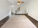 Spacious living room featuring hardwood floors and a ceiling fan with stairs in the background at 149 Fishers Mill Dr, Mcdonough, GA 30252