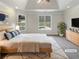 Staged main bedroom featuring tray ceiling, large windows, and neutral tones at 149 Fishers Mill Dr, Mcdonough, GA 30252