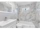 Bright bathroom featuring marble tile, modern vanity, and bathtub with shower at 174 Howard Nw St, Atlanta, GA 30314