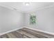 Bedroom with a large window, neutral paint, and new vinyl flooring at 174 Howard Nw St, Atlanta, GA 30314