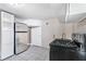 Kitchen featuring a modern stainless steel refrigerator, white cabinets, tile flooring, and a black oven at 174 Howard Nw St, Atlanta, GA 30314