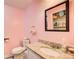 Bright pink bathroom with a granite countertop, a white toilet, and a decorative mirror at 1834 Buckeye Sw St, Atlanta, GA 30310