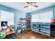 Bright blue bedroom featuring hardwood floors, shelves, and two large windows at 1834 Buckeye Sw St, Atlanta, GA 30310