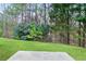 Scenic backyard view featuring lush green grass and mature trees, creating a private and serene outdoor space at 184 Darbys Crossing Ct, Hiram, GA 30141