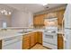 Kitchen with white appliances, wooden cabinets and tile backsplash at 184 Darbys Crossing Ct, Hiram, GA 30141