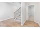 Bright hallway featuring hardwood floors, a staircase with iron railings, and a doorway leading to another room at 7164 Brushwood Bend (Lot 111), Lithonia, GA 30058