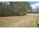 Wide backyard with a lawn and a wooden fence with trees in the background at 7717 Bellmist Dr, Fairburn, GA 30213