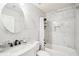 Bright bathroom featuring sleek marble tiling, modern fixtures, and a shower-tub combination at 7717 Bellmist Dr, Fairburn, GA 30213