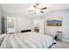 Bedroom featuring neutral paint, a ceiling fan, and open access to the en-suite bathroom and bonus room at 7717 Bellmist Dr, Fairburn, GA 30213