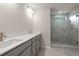 Bright bathroom with a double sink vanity, grey cabinets and a tiled glass shower at 1733 Lansmere Sw St, Marietta, GA 30008
