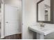 A modern bathroom featuring a pedestal sink, stylish mirror, and door to another room at 1733 Lansmere Sw St, Marietta, GA 30008