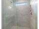 This tiled shower features a built in shower caddy, rainfall shower head and glass door at 1733 Lansmere Sw St, Marietta, GA 30008