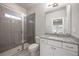 Bathroom with a gray tiled shower and a white vanity with a granite countertop and modern fixtures at 475 Rowes Cir, Alpharetta, GA 30009