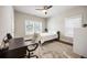 Bright bedroom with a ceiling fan, two windows, a desk, and a patterned rug over hardwood floors at 475 Rowes Cir, Alpharetta, GA 30009