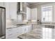 Bright kitchen features stainless steel appliances, white cabinets, and stone countertops at 475 Rowes Cir, Alpharetta, GA 30009