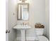 Clean powder room with pedestal sink, modern mirror, and neutral decor at 475 Rowes Cir, Alpharetta, GA 30009