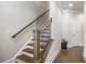 A staircase featuring wooden steps and a dark metal railing with a wooden handrail leads to the next level of the home at 475 Rowes Cir, Alpharetta, GA 30009